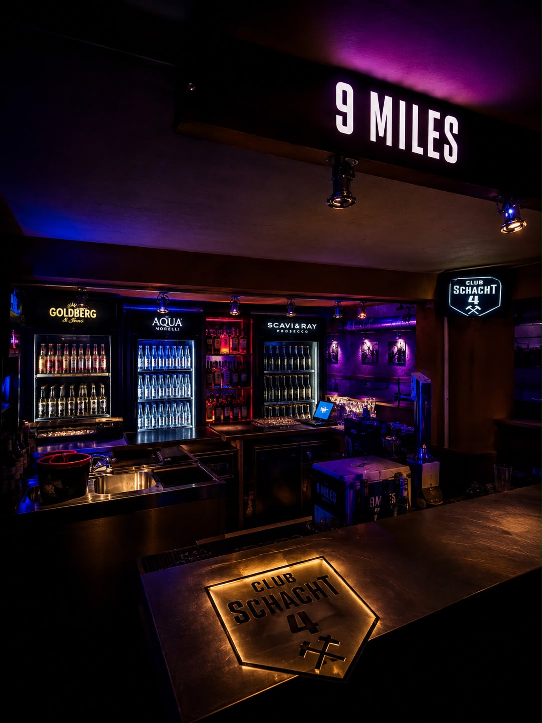 Neon-beleuchtete Bar im Club Schacht 4 mit Leuchtschildern CLUB SCHACHT 4 und 9 MILES in Pink und Blau